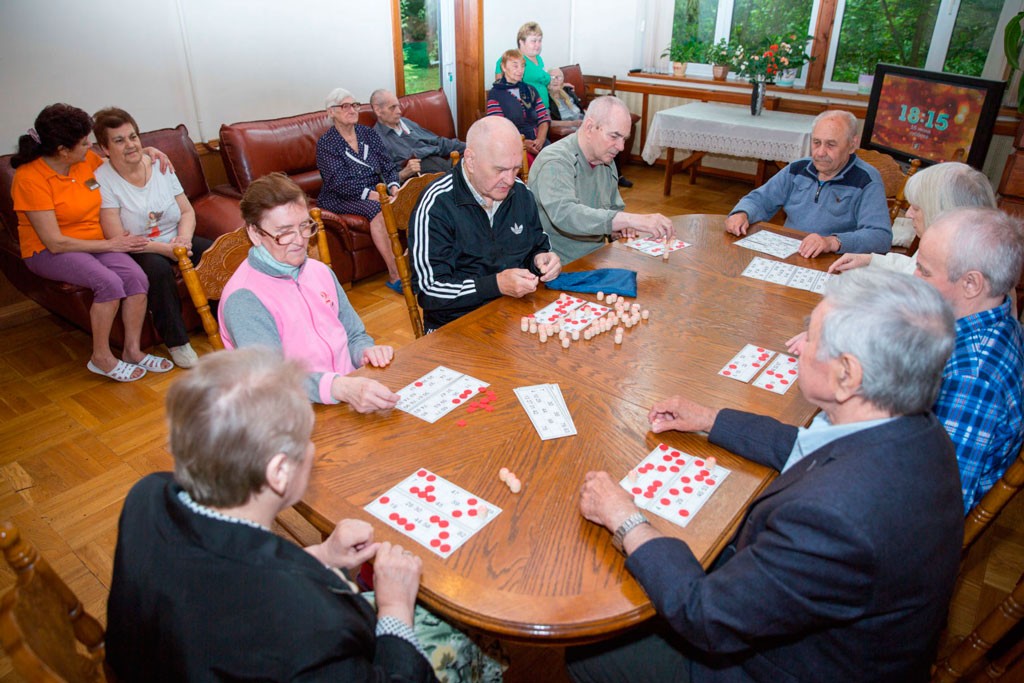 Восемь людей пожилого возраста играет в настольные игры