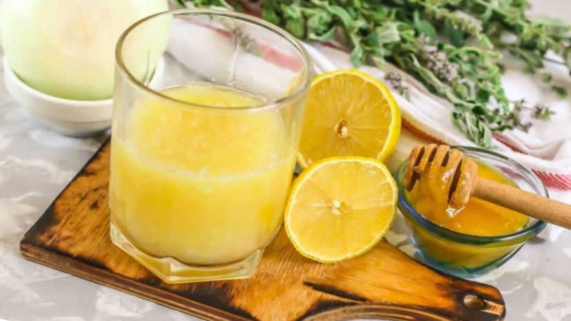 жёлтая смесь из воды, лимона и мёда в прозрачном стакане